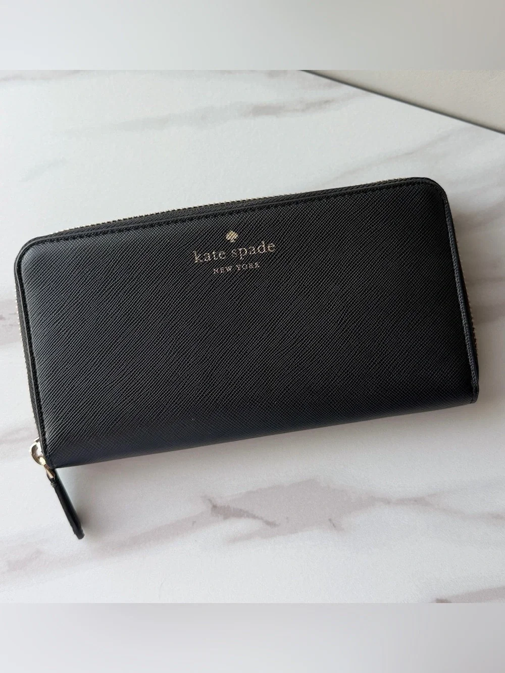 Kate Spade black saffiano leather zip-around continental wallet.
